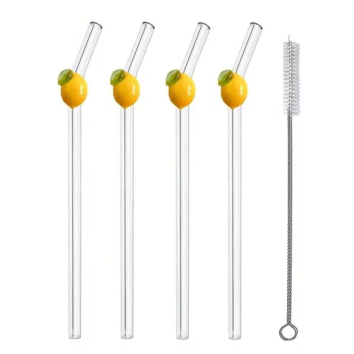 Four clear glass drinking straws with yellow and green lemon designs on the upper portion, shown alongside one metal cleaning brush on a white background, with text reading '4Pcs+1Cleaning Brush'.